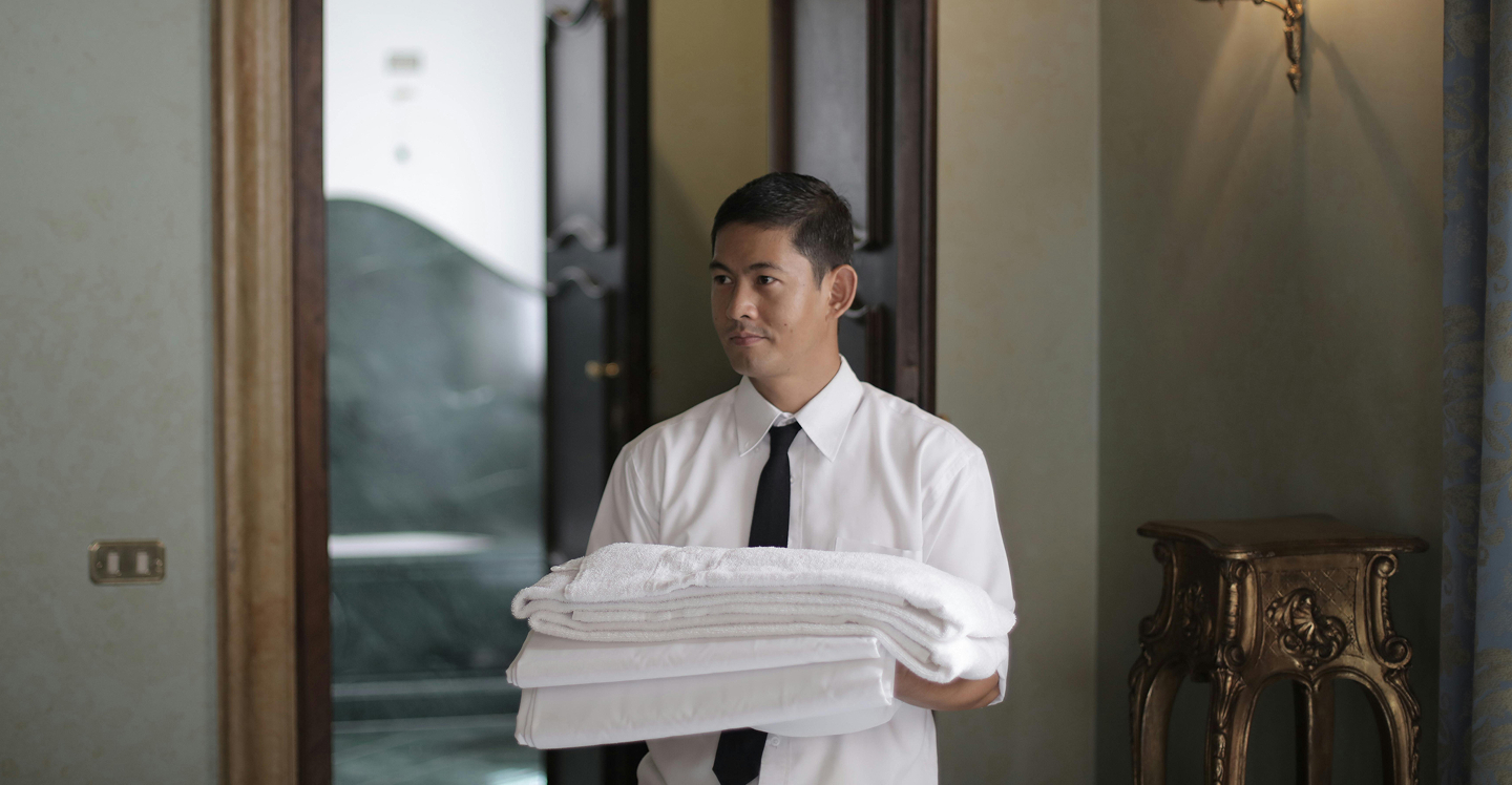 Hotel staff member carrying fresh towels